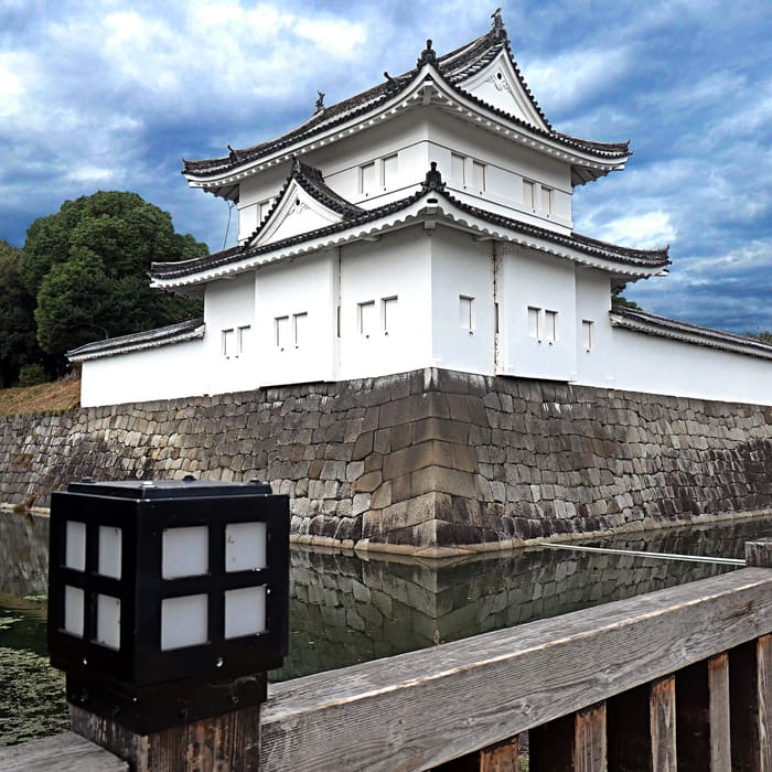 El torreón blanco de esquina del castillo de Nijo sobre su muralla y su foso